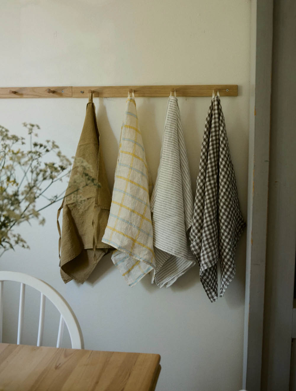 Linen towels from Linge Particulier hanging on hooks